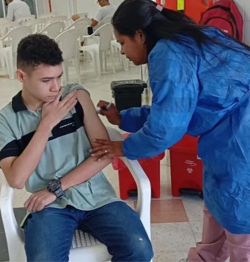 Profesional de salud aplicando una vacuna a un joven durante una jornada de inmunización en Barranquilla
