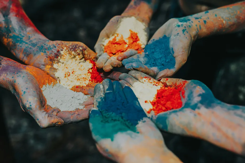Polvos de colores elevándose durante la celebración del festival Holi. Foto de Sandra Seitamaa en Unsplash.