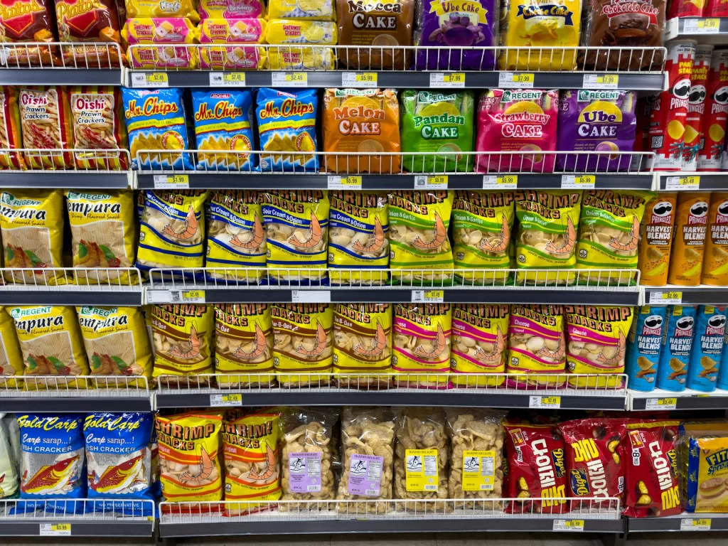 Estantes llenos de snacks ultraprocesados en un supermercado, representando el consumo habitual de productos que deterioran la salud. Foto de Allen Boguslavsky en Pexels.