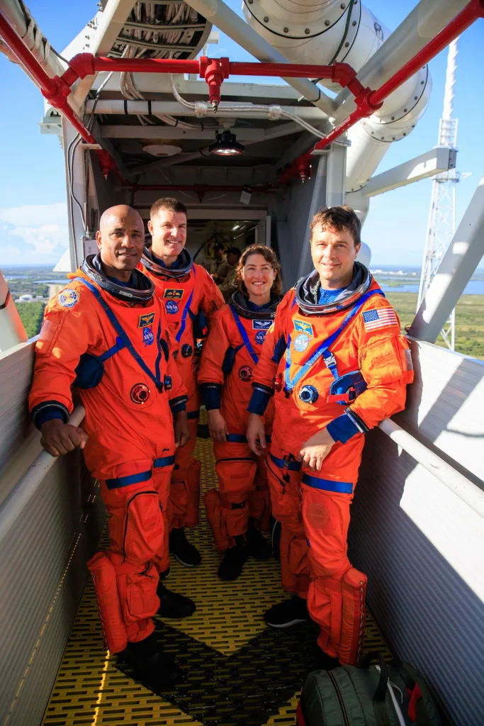 Los astronautas Victor Glover, Jeremy Hansen, Christina Koch y Reid Wiseman posan en el brazo de acceso a la tripulación del lanzador móvil durante una prueba de Artemis II en el Centro Espacial Kennedy. Crédito: NASA/Frank Michaux.