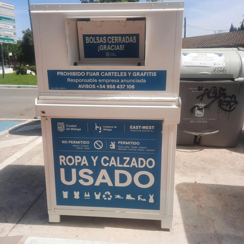 Contenedor blanco y azul para ropa y calzado usado en una calle de Churriana.