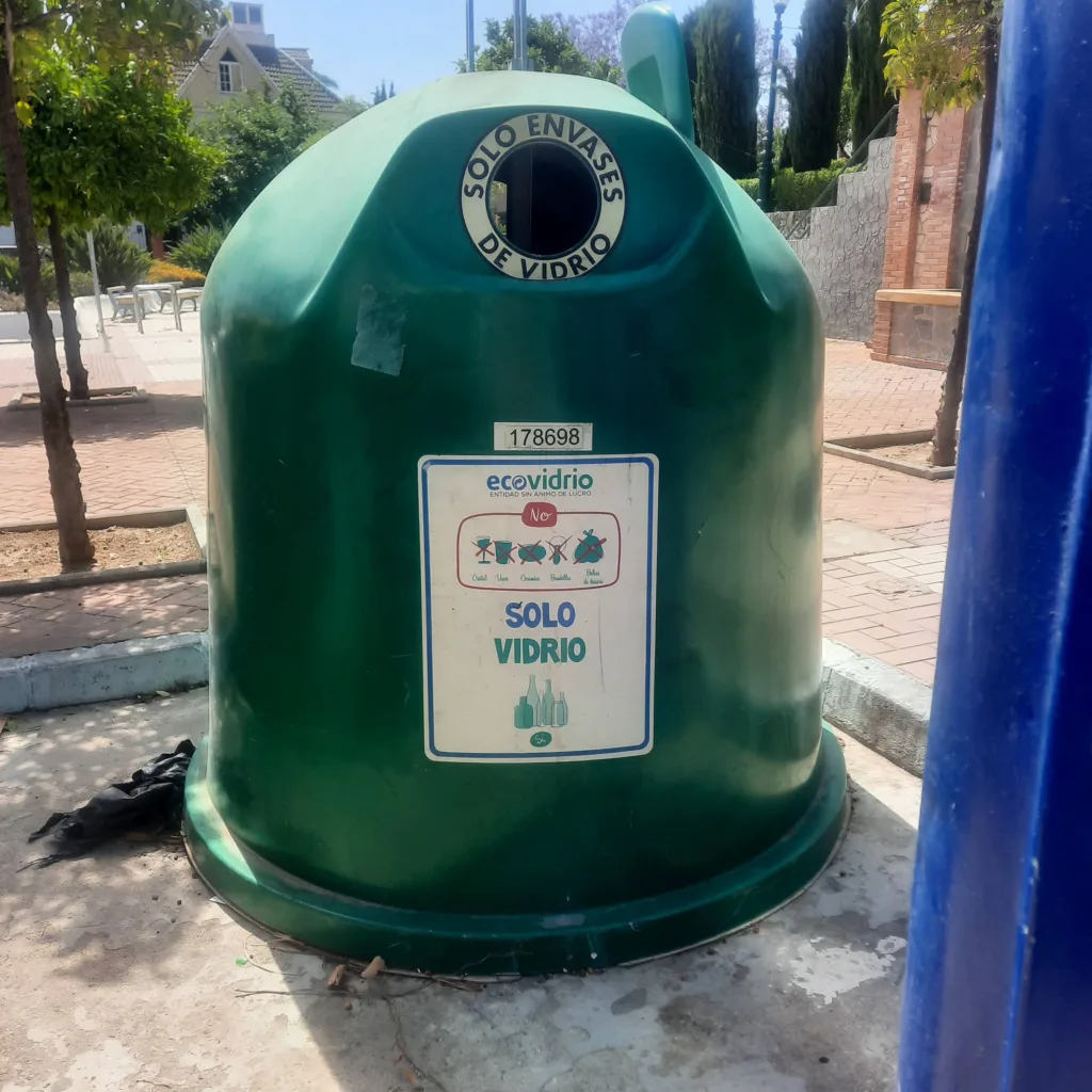 Contenedor verde para reciclaje de vidrio en una calle de Churriana.