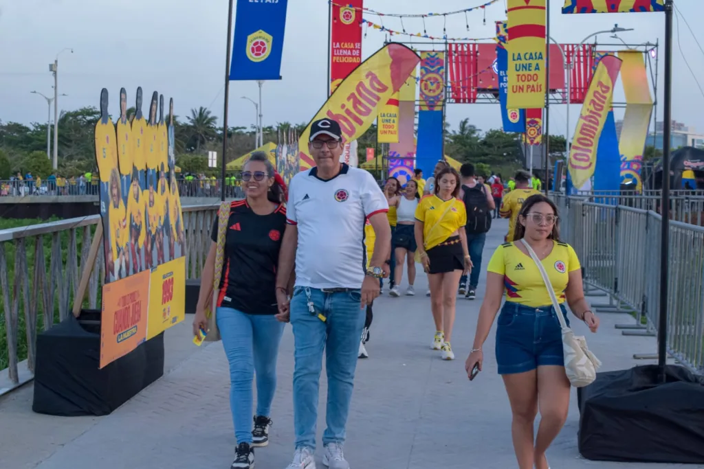 Hinchas de Colombia caminan por el fan zone del Gran Malecón entre decoraciones mundialistas y figuras de jugadores.