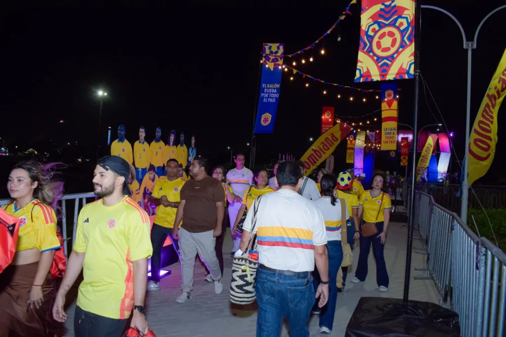 Hinchas de Colombia caminan por el fan zone del Gran Malecón entre decoraciones mundialistas y figuras de jugadores.