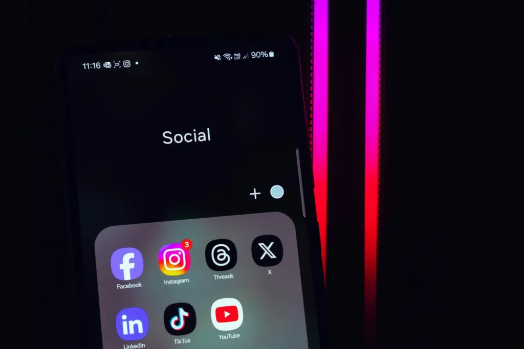 Iconos de redes sociales en la pantalla de un móvil, representando el uso digital juvenil y la regulación del acceso para menores. Foto de Panos Sakalakis en Unsplash